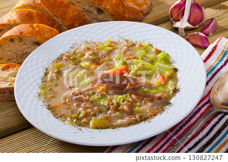 Lamb's soup cooked with pearl barley, green peas and cabbage 130827247