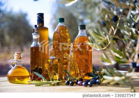 Various kinds of oil on the table on background of olive tree Various kinds of oil on the table on background of olive tree 130827347