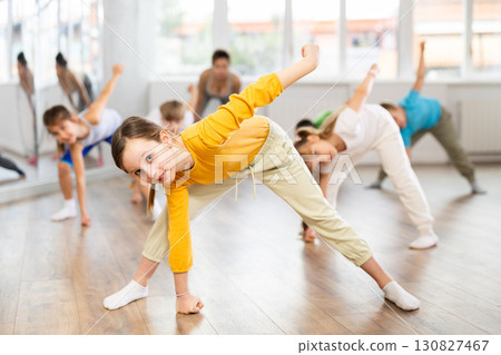 Happy smiling preteen dancers practicing dance routine with female choreographer in studio Happy smiling preteen dancers practicing dance routine with female choreographer in studio 130827467