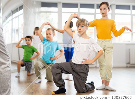Happy preteen children practicing ballroom dances in pairs in training hall 130827603