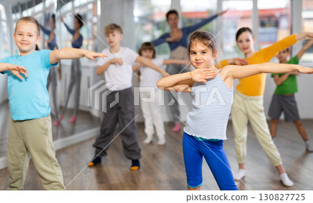 Children studying modern style dances with female teacher in dance class Children studying modern style dances with female teacher in dance class 130827725