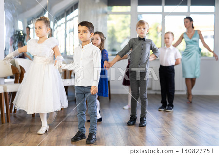 Preteen girls and boys performing curtsy and bow during festive dance event 130827751