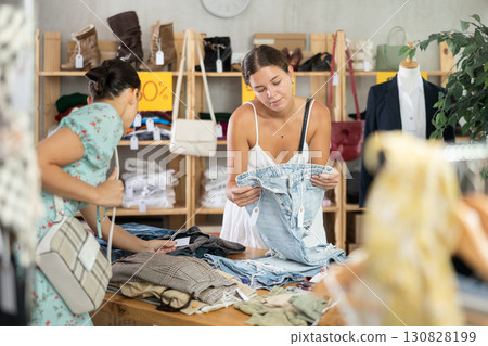 Two selective young woman choosing pantaloons in clothing store 130828199