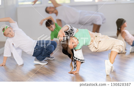 Preteen boys and girls studying movement of contemporary dance in classroom with his friends 130828387