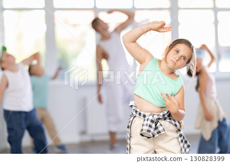 Portrait of happy girl enjoying hip-hop with group children in dance room 130828399
