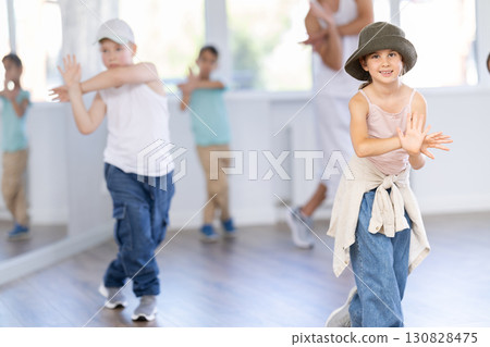Girls and boys training hip hop in dance studio, dance classes for kids Girls and boys training hip hop in dance studio, dance classes for kids 130828475