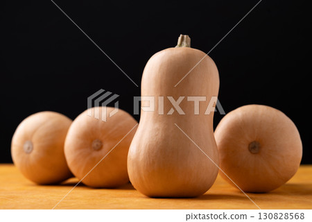 Fresh butternut squash pumpkin on orange and black background 130828568