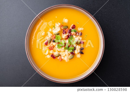 Top view of Butternut squash pumpkin soup in a bowl on black background 130828598