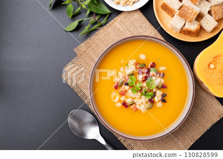 Top view of Butternut squash pumpkin soup in a bowl on black background 130828599