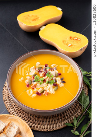 Butternut squash pumpkin soup in a bowl on black background, Homemade food in autumn season 130828600