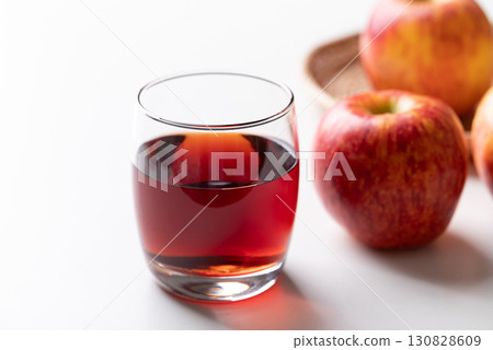 Glass of apple cider with red apple fruit on white background Glass of apple cider with red apple fruit on white background 130828609