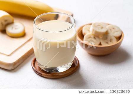 Banana milk in glass with sliced banana and fruit on white background 130828620