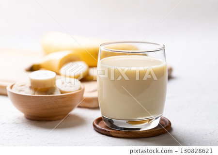 Banana milk in glass with sliced banana and fruit on white background 130828621