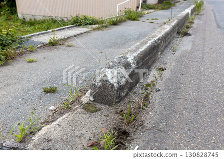 Damaged sidewalk/road boundary block 130828745