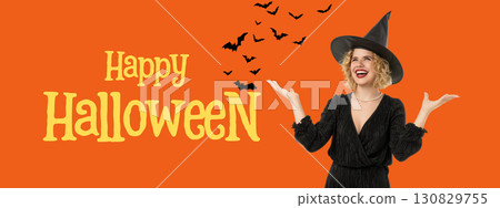 Woman with curly hair wearing a witch hat celebrates Halloween 130829755