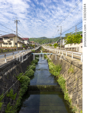 A view of a new residential area built on the slope of a mountain and a river 130830844