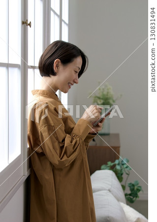 A woman who manipulates a smartphone at the window side A woman who manipulates a smartphone at the window side 130831494