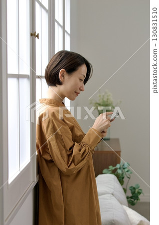 A woman who manipulates a smartphone at the window side A woman who manipulates a smartphone at the window side 130831510