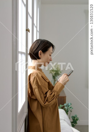 A woman who manipulates a smartphone at the window side A woman who manipulates a smartphone at the window side 130831520