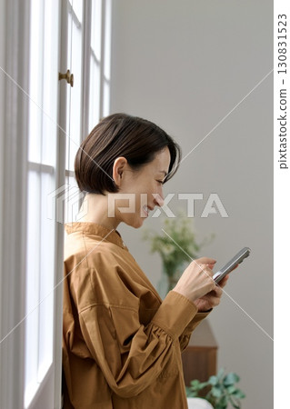 A woman who manipulates a smartphone at the window side 130831523