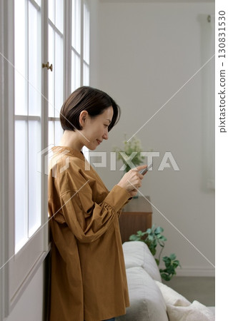 A woman who manipulates a smartphone at the window side A woman who manipulates a smartphone at the window side 130831530