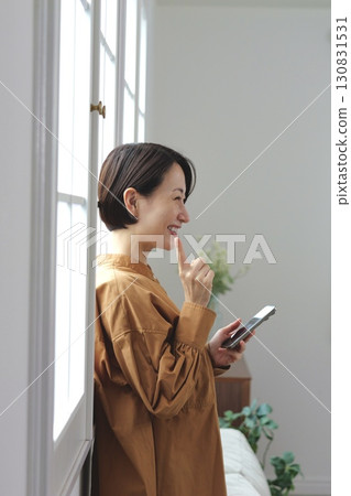 A woman who manipulates a smartphone at the window side A woman who manipulates a smartphone at the window side 130831531