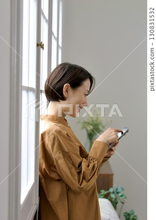 A woman who manipulates a smartphone at the window side A woman who manipulates a smartphone at the window side 130831532