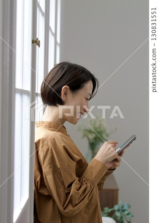 A woman who manipulates a smartphone at the window side 130831551