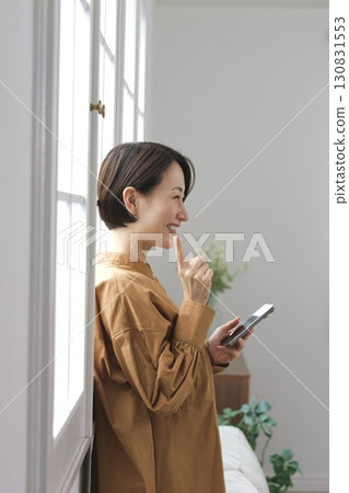 A woman who manipulates a smartphone at the window side A woman who manipulates a smartphone at the window side 130831553