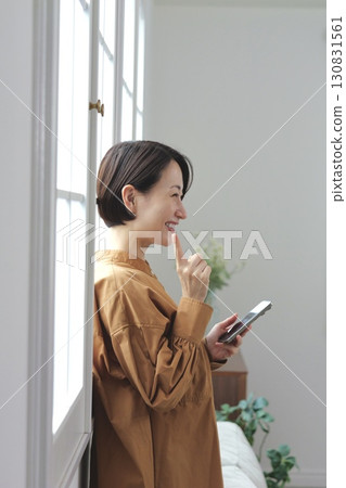 A woman who manipulates a smartphone at the window side A woman who manipulates a smartphone at the window side 130831561