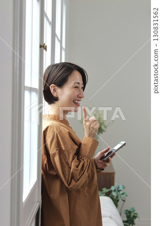 A woman who manipulates a smartphone at the window side 130831562