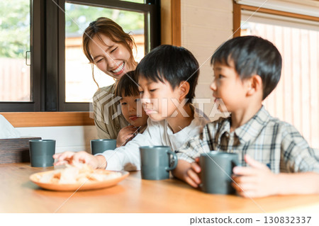 Parents and children eating snacks and potato chips for a 3 o'clock snack Parents and children eating snacks and potato chips for a 3 o'clock snack 130832337
