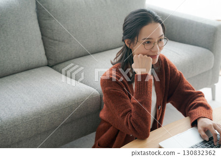 一位女士在客廳操作電腦 130832362