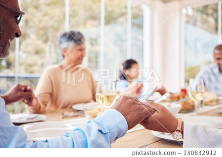 Praying, spiritual and family praise God before dinner or supper as gratitude together in dining room. Holding hands, religion and thankful Christian people in hope, worship and prayer at a table 130832912