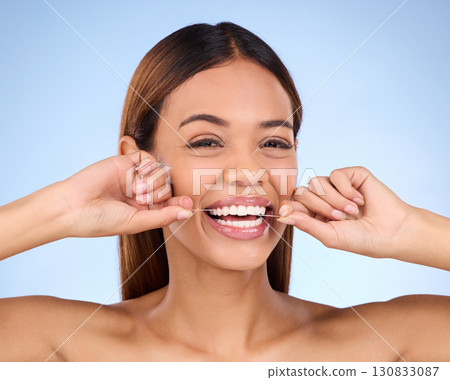 Dental floss, portrait and woman smile with teeth hygiene, healthcare and wellness treatment. Isolated, blue background and studio with a female feeling beauty from a clean mouth with self care 130833087