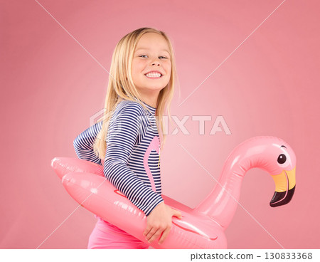 Happy, portrait and pool float with girl in studio for swimming, summer break or cute. Youth, funny and inflatable with child and flamingo ring for relax, smile or beach holiday on pink background Happy, portrait and pool float with girl in studio for swimming, summer break or cute. Youth, funny and inflatable with child and flamingo ring for relax, smile or beach holiday on pink background 130833368