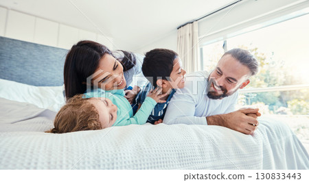 Happy, love and family being playful on the bed together in the bedroom of their modern house. Happiness, excited and children having fun, playing and bonding with their parents in a room at home. Happy, love and family being playful on the bed together in the bedroom of their modern house. Happiness, excited and children having fun, playing and bonding with their parents in a room at home. 130833443