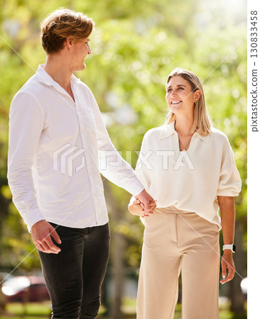 Love, park and a couple holding hands while walking together outdoor in nature while on a romantic summer date. Trust, romance or affection with a man and woman bonding during a walk in the garden 130833458
