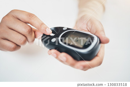 Diabetes, blood test and medical with finger of woman for insulin level, monitoring and glucose check. Medicine, healthcare and digital with hands of patient and glucometer machine for sugar balance 130833518