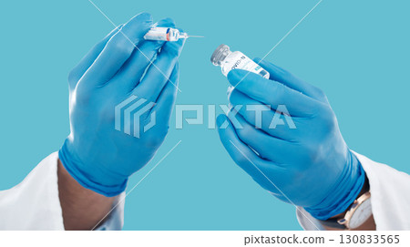 Closeup, hands and needle for vaccine, healthcare and research with blue studio background. Zoom, gloves and liquid bottle with medical equipment, medicine and vial for cure, vaccination and results Closeup, hands and needle for vaccine, healthcare and research with blue studio background. Zoom, gloves and liquid bottle with medical equipment, medicine and vial for cure, vaccination and results 130833565