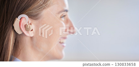 Mockup, deaf and woman with ear piece, disability and health against a grey studio background. Female, lady and hearing aid for help, success with tech and happiness with listening device and medical 130833658