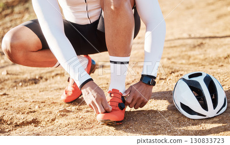 Closeup, tie shoelace and man with fitness, outdoor and helmet for safety, wellness and hobby for exercise. Zoom, shoes and male athlete with protection, sand and in nature for training and workout 130833723