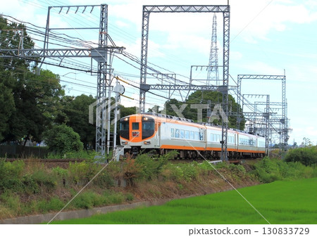 A Kintetsu Limited Express train running on an embankment in a rice field on the Kintetsu Kashihara Line in Nara Prefecture 130833729