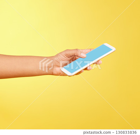 Hands, phone mockup and green screen in studio isolated on a yellow background. Cellphone, social media and black woman holding mobile smartphone for advertising space, marketing or product placement 130833836