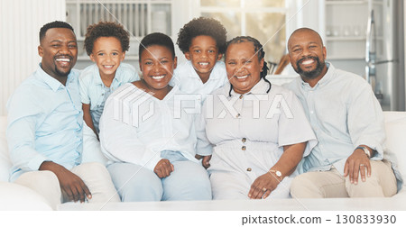 Happy, together and portrait of a black family on a sofa for bonding, visit or quality time. Smile, group and African parents, children and grandparents on a couch for generations in the lounge 130833930