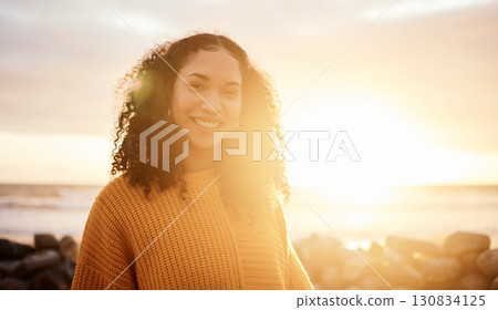 Travel, sunset and portrait of a woman at the beach while on a zen vacation or weekend trip. Happy, smile and calm female from Puerto Rico by the ocean while on a seaside holiday or adventure. 130834125