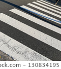 A lone person walking diagonally across a crosswalk at dusk A lone person walking diagonally across a crosswalk at dusk 130834195
