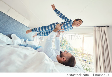 Father, son and dad playing with his child on a bed holding him having fun in a bedroom feeling happy, carefree and excited. Parent, kid and dad bonding with young boy in a house together Father, son and dad playing with his child on a bed holding him having fun in a bedroom feeling happy, carefree and excited. Parent, kid and dad bonding with young boy in a house together 130834304