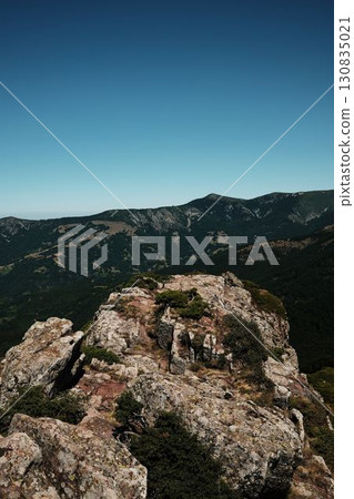 Rocky cliffs and green slopes of Stara Planina with mountain ridges in the distance. Babin Zub mount in summer season. Serbia country Rocky cliffs and green slopes of Stara Planina with mountain ridges in the distance. Babin Zub mount in summer season. Serbia country 130835021