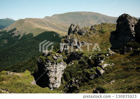 Rocky cliffs and green slopes of Stara Planina with mountain ridges in the distance. Babin Zub mount in summer season. Serbia country Rocky cliffs and green slopes of Stara Planina with mountain ridges in the distance. Babin Zub mount in summer season. Serbia country 130835023